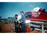 1968 : VH-UHD after transmission failure in the Simpson Desert. This photos taken after main blades had been removed and a fence was being erected to protect the machine from feral camels (L-R) Paul McCormack & Lawrie O'Connor.
